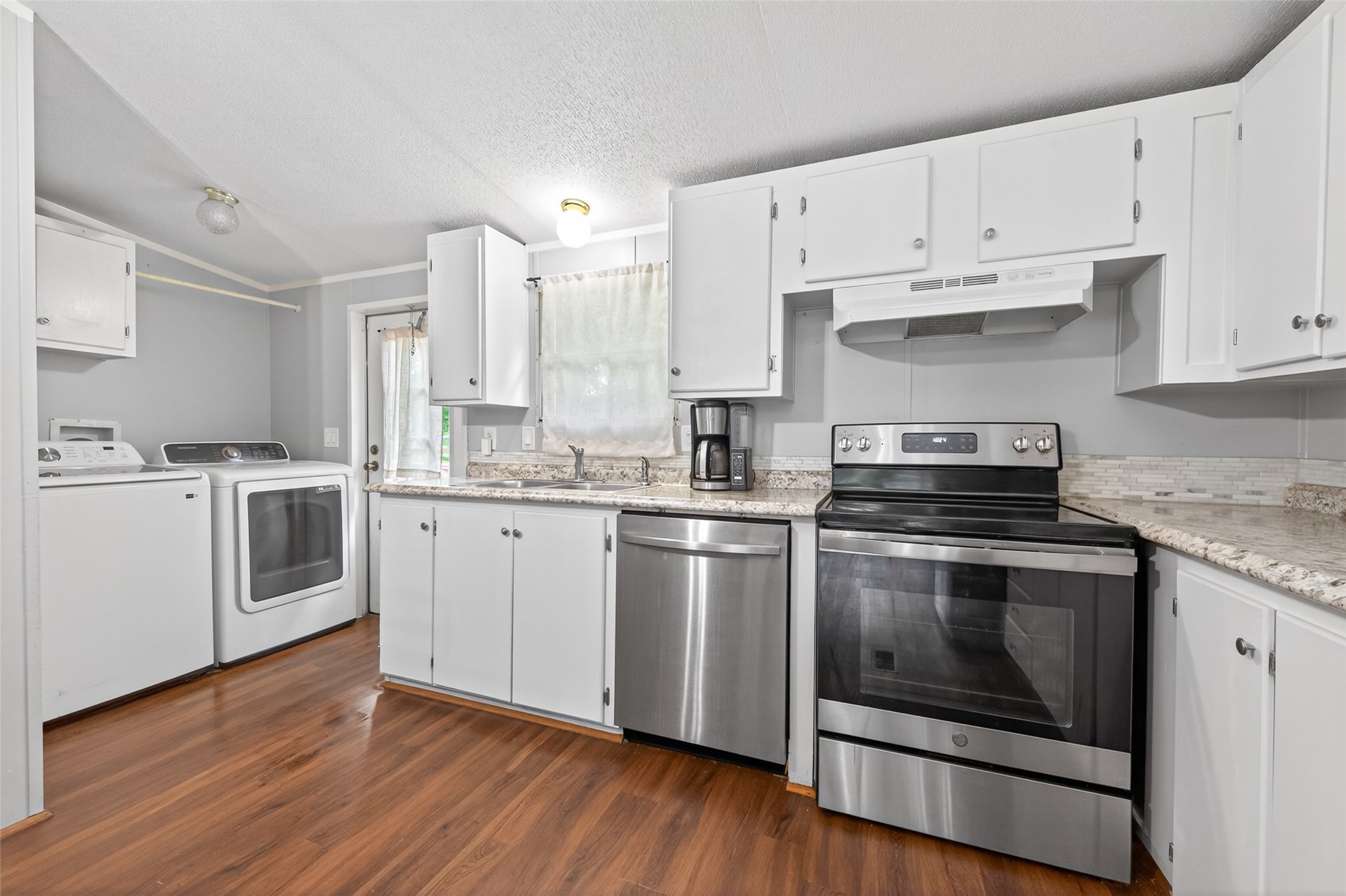 16572 River Ranch Drive Conroe, TX 77302 - Photo 6 of 18 a kitchen with cabinets stainless steel appliances and wooden floor