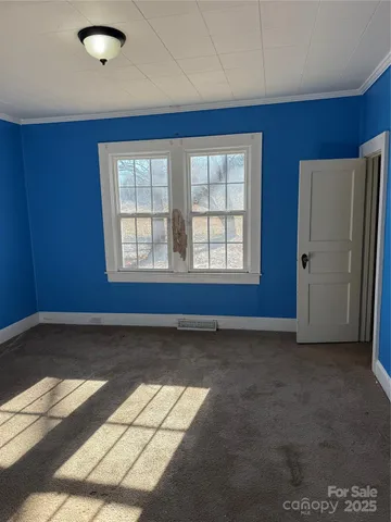 a view of a hallway with wooden floor and windows