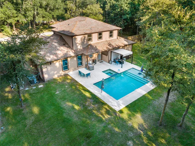 a view of a house with pool and chairs