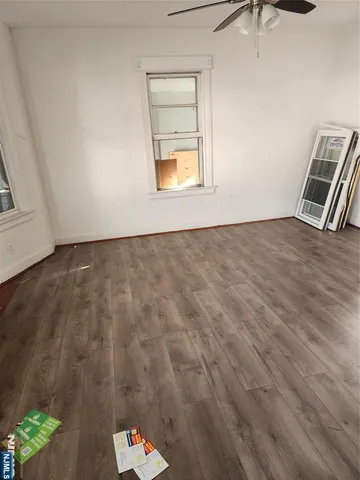 en empty room with wooden floor and window