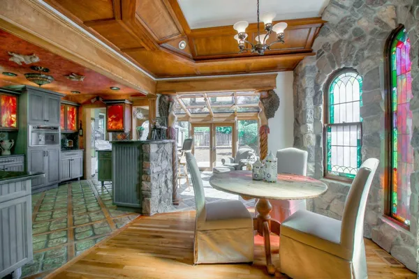 a living room with stainless steel appliances furniture a rug and a kitchen view