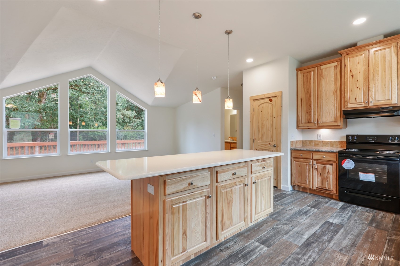 18737 Hilt Street Southwest Rochester, WA 98579 - Photo 5 of 29 a kitchen with kitchen island granite countertop a stove a sink and white cabinets with wooden floor