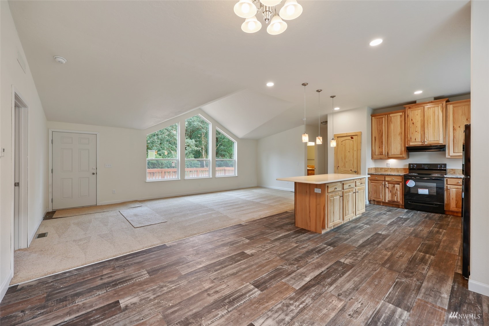 18737 Hilt Street Southwest Rochester, WA 98579 - Photo 8 of 29 a large kitchen with kitchen island granite countertop a stove a sink a refrigerator and white cabinets with wooden floor