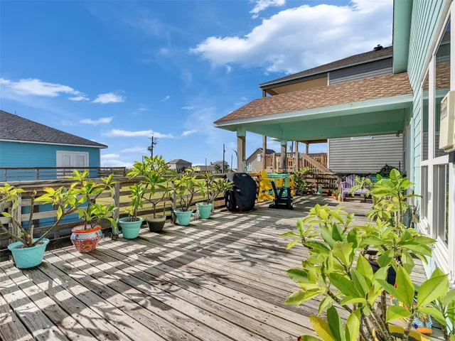 a kitchen with stainless steel appliances granite countertop a refrigerator a stove a sink a dining table and chairs with wooden floor