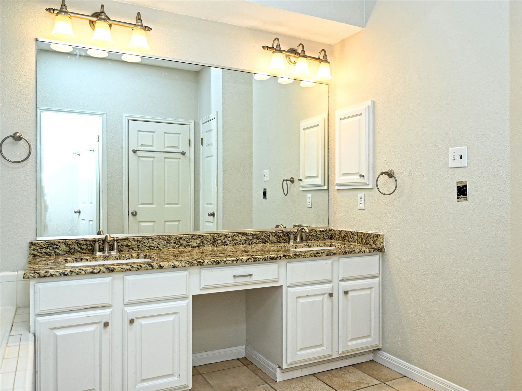 11017 Rio Vista Drive Austin, TX 78726 - Photo 25 of 38 Double vanity featuring white cabinetry, a light-colored countertop, and dual sinks with brushed nickel fixtures