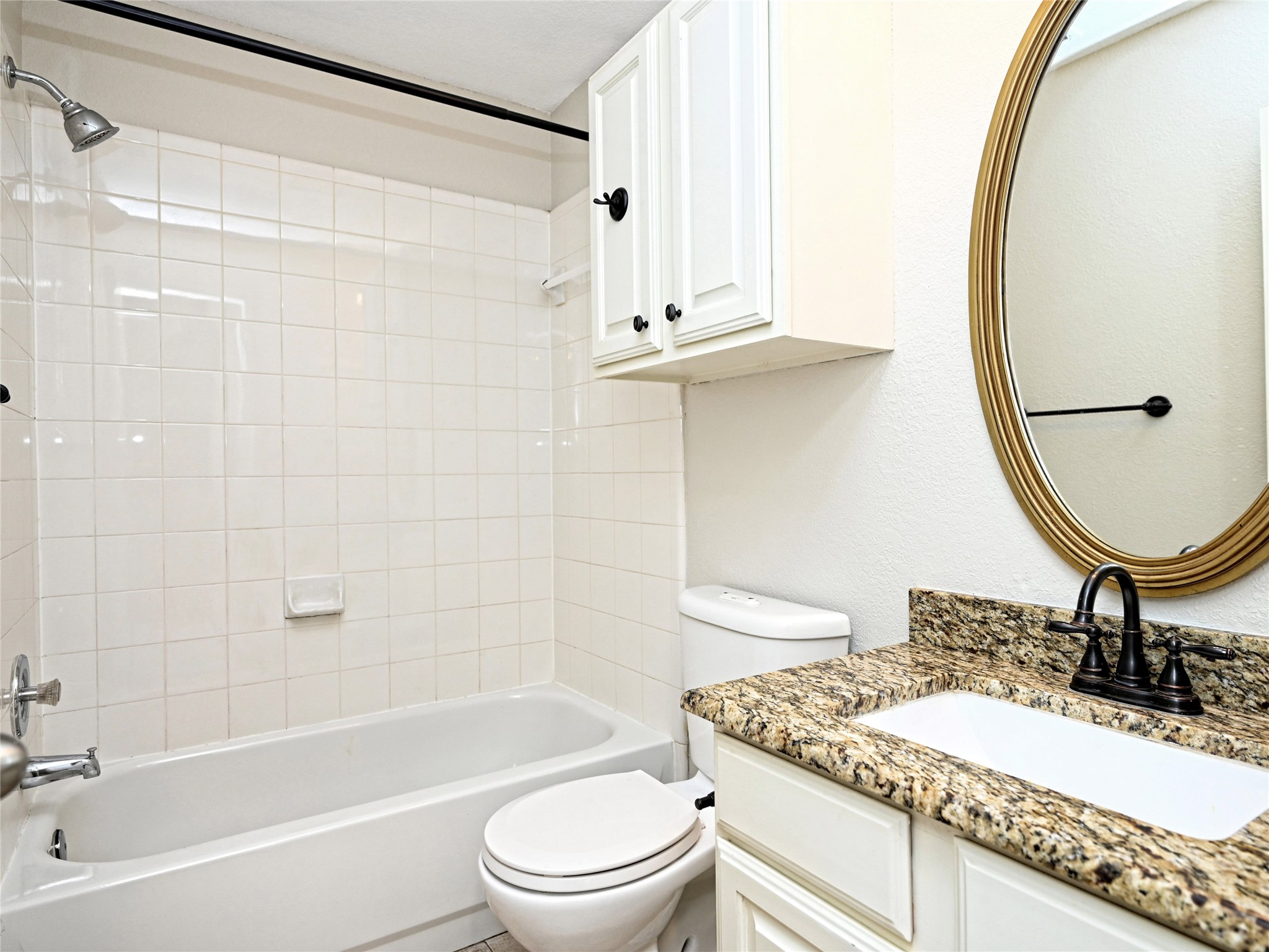 11017 Rio Vista Drive Austin, TX 78726 - Photo 29 of 38 Bathroom featuring a white bathtub, white tile surround, and a chrome shower head