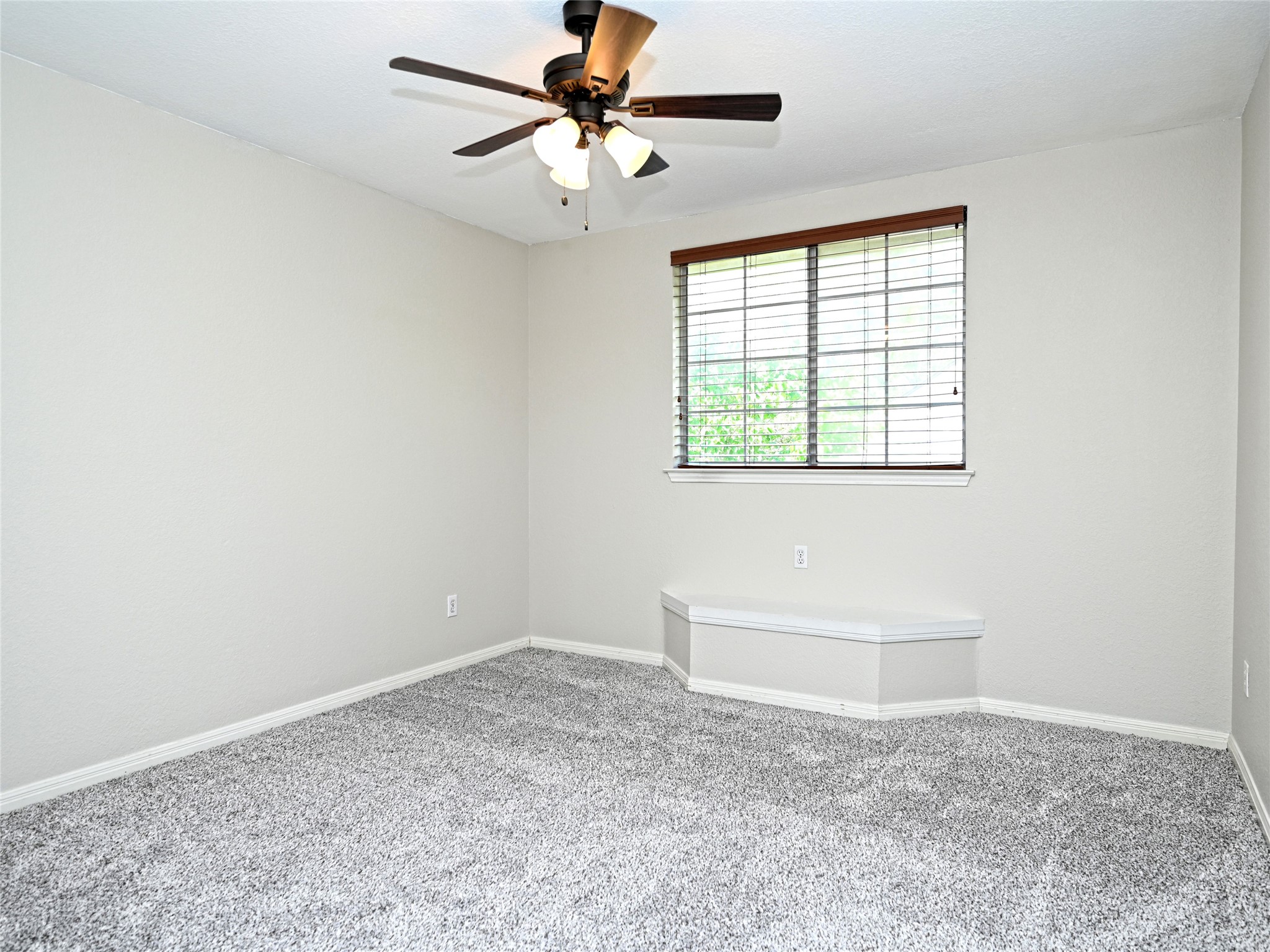 11017 Rio Vista Drive Austin, TX 78726 - Photo 31 of 38 Spacious room featuring light gray carpeting, a built-in window bench, and a ceiling fan with integrated lighting