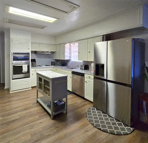 a kitchen with stainless steel appliances a stove a sink refrigerator and cabinets