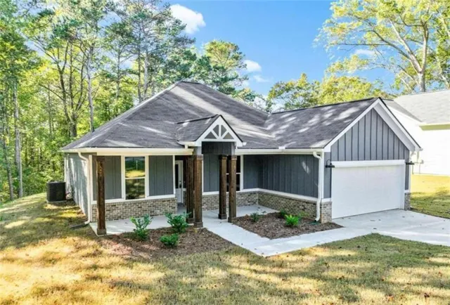 a view of a white house with a small yard plants and large tree