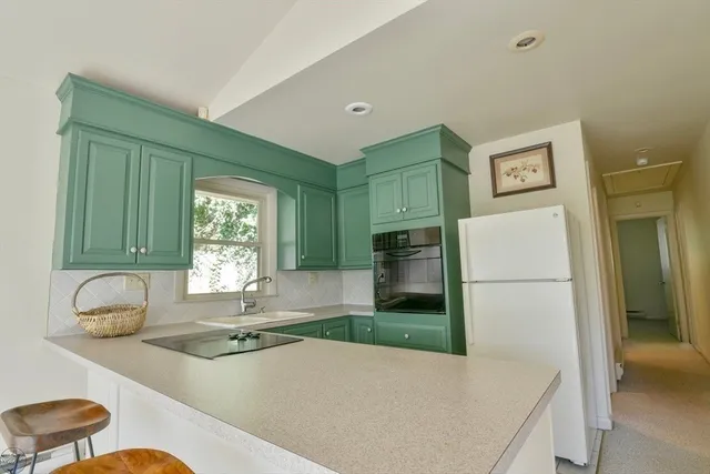 a kitchen with a refrigerator and a stove top oven