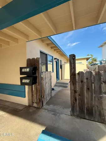 a view of a blue house with a outdoor space