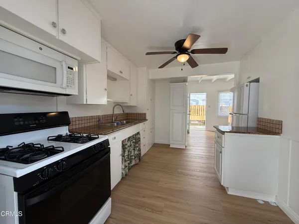 a kitchen with granite countertop a stove and a wooden floors