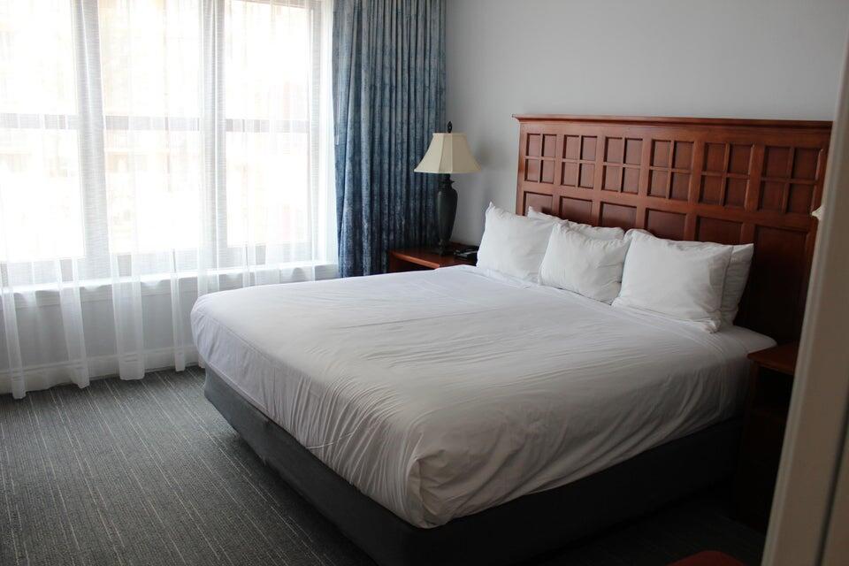 10 Harbor Boulevard, Unit 203B Destin, FL 32541 - Photo 7 of 18 a bed sitting in a bedroom next to a window