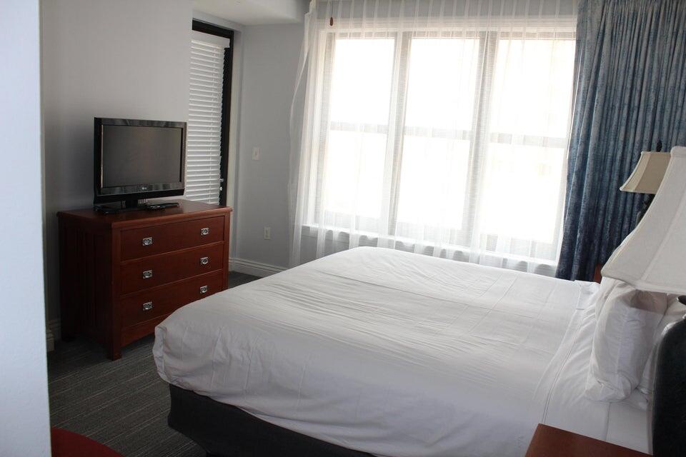 10 Harbor Boulevard, Unit 203B Destin, FL 32541 - Photo 8 of 18 a bedroom with a bed and a flat screen tv