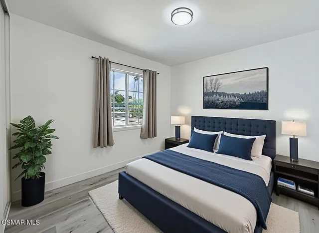 a bedroom with a large bed and a potted plant