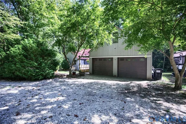 a backyard of a house with large trees and a barn