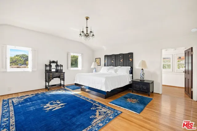 a bedroom with a bed dresser and a wooden floor