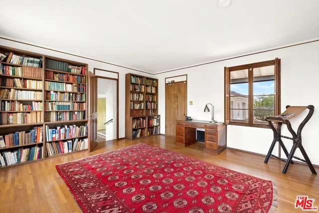 a living room with furniture a rug and a book shelf