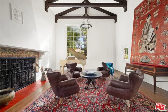a living room with furniture a rug a fireplace and a window