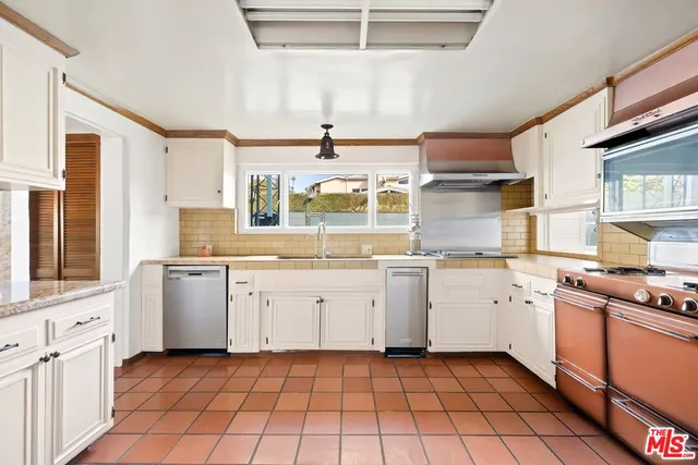 a kitchen with a stove window and cabinets