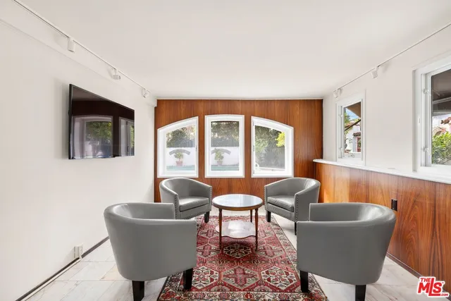a living room with furniture a flat screen tv and a large window