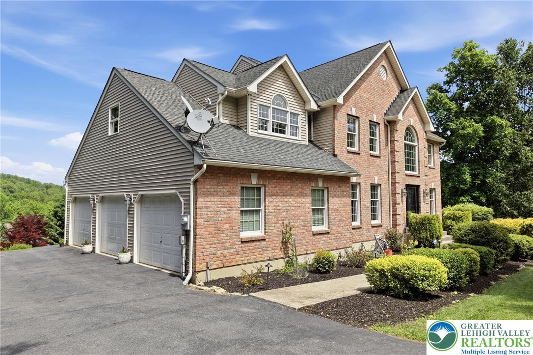 115 West Butternut Road Hellertown, PA 18055 - Photo 97 of 97 A classic brick and siding home presents a graceful facade with a spacious three-car garage and manicured landscaping.