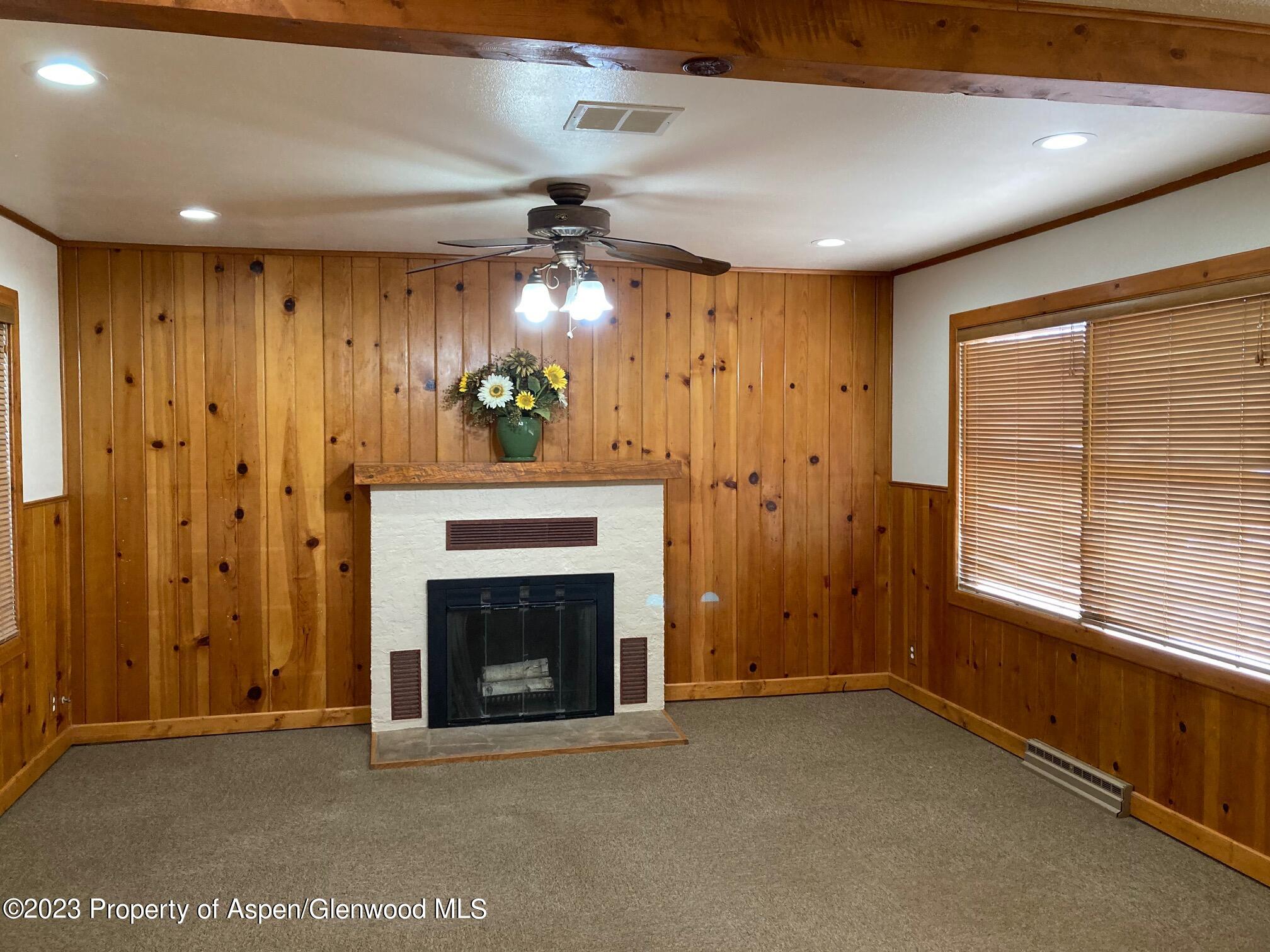 426 East 11th Street Rifle, CO 81650 - Photo 4 of 12 a view of an empty room with a fireplace and a window