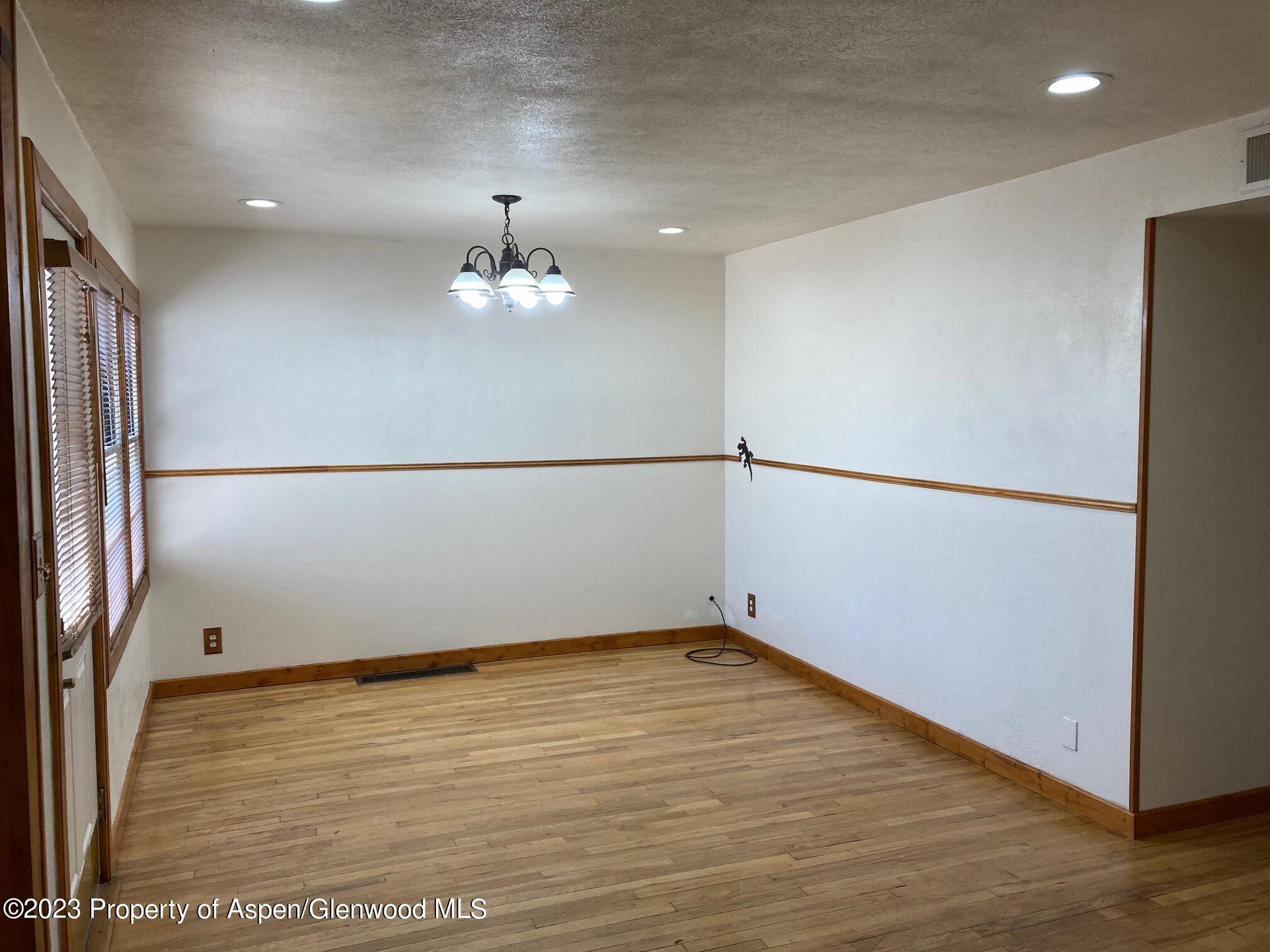 426 East 11th Street Rifle, CO 81650 - Photo 5 of 12 a view of an empty room with wooden floor and a window