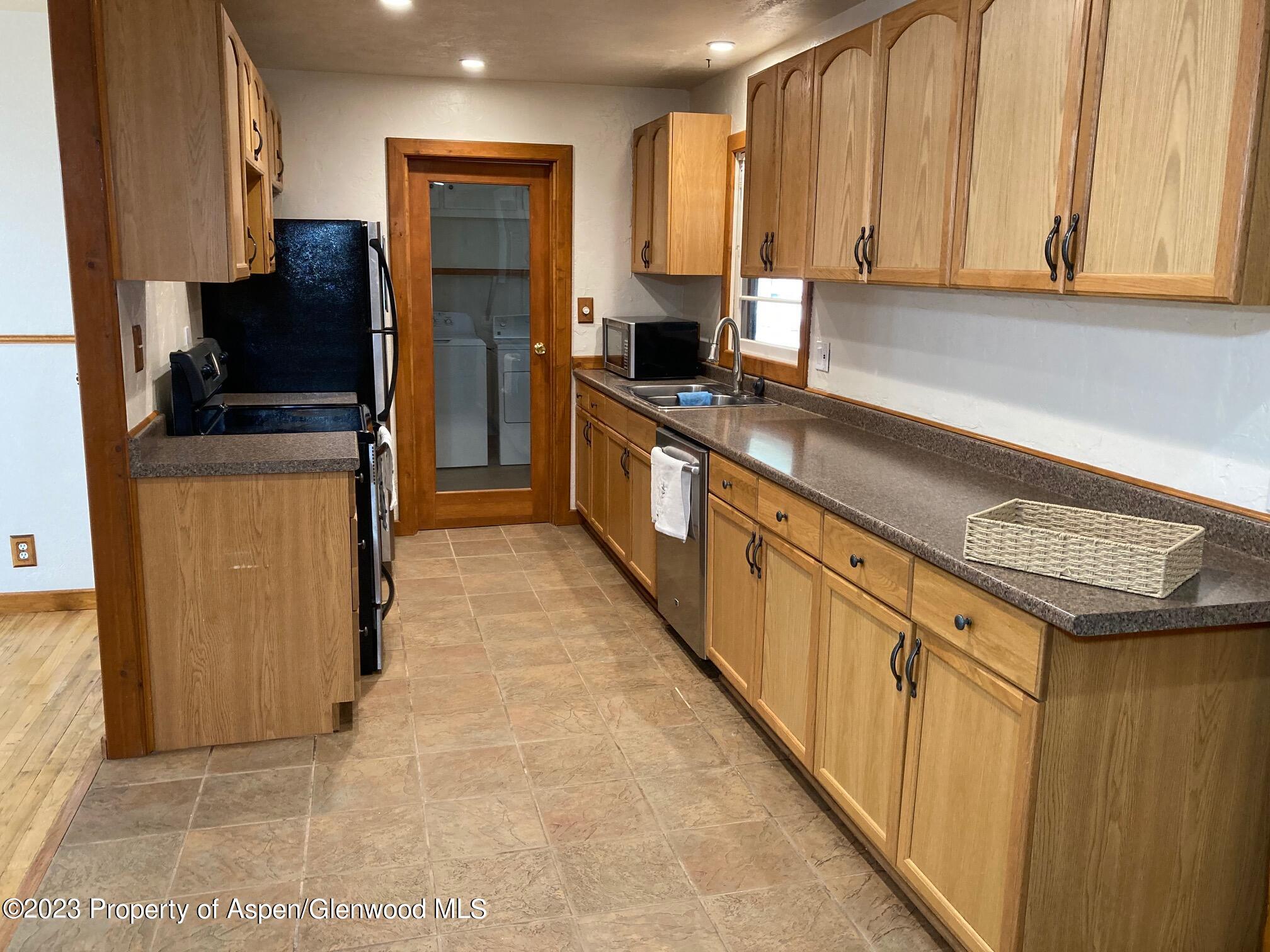 426 East 11th Street Rifle, CO 81650 - Photo 6 of 12 a kitchen with stainless steel appliances a sink a stove and a refrigerator