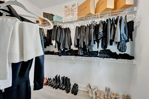 a view of walk in closet with clothes and shoes