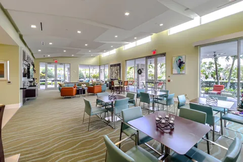 a living room with furniture kitchen view and a wooden floor