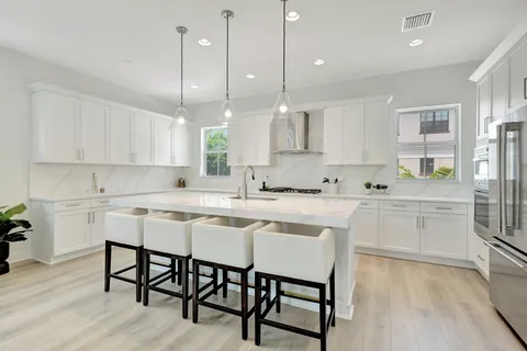 a kitchen with stainless steel appliances granite countertop a white cabinets and wooden floors