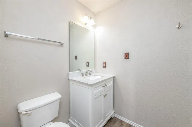 a bathroom with a toilet a sink a vanity and mirror