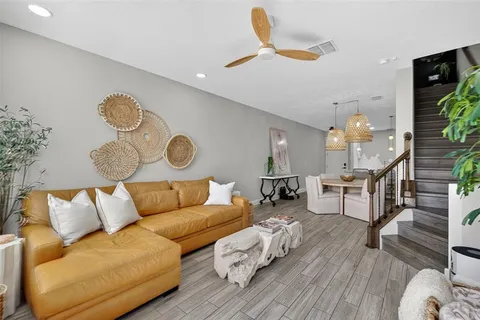 a living room with furniture and a wooden floor