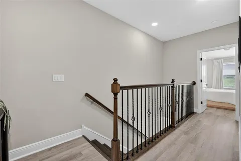 a view of a hallway with wooden floor and windows