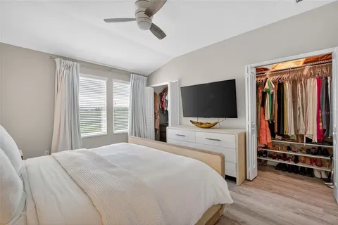 a bedroom with a bed tv and white walls