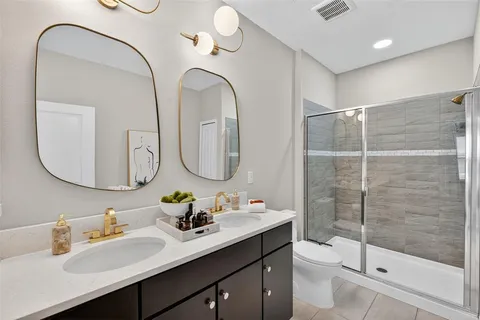 a bedroom with a bed and a mirror on the dresser