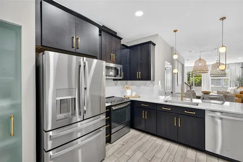 a kitchen with stainless steel appliances a sink stove and refrigerator
