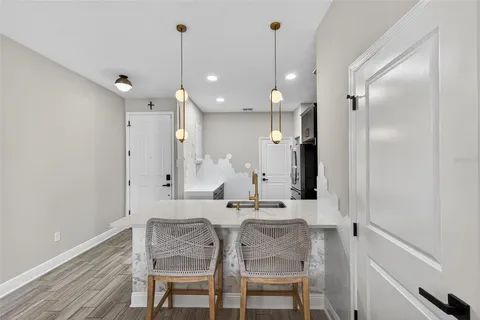 a dining area with a table chairs refrigerator and microwave