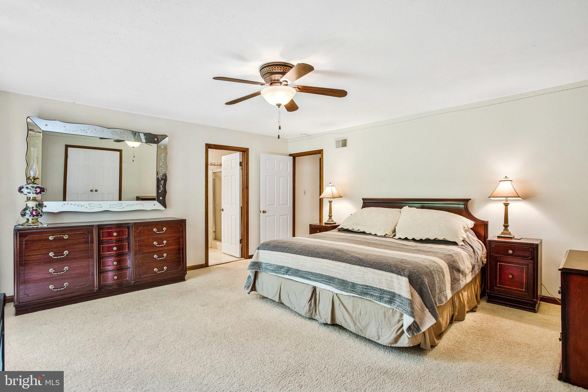 1021 Carson Drive Huntingtown, MD 20639 - Photo 15 of 33 a spacious bedroom with a large bed and a dresser