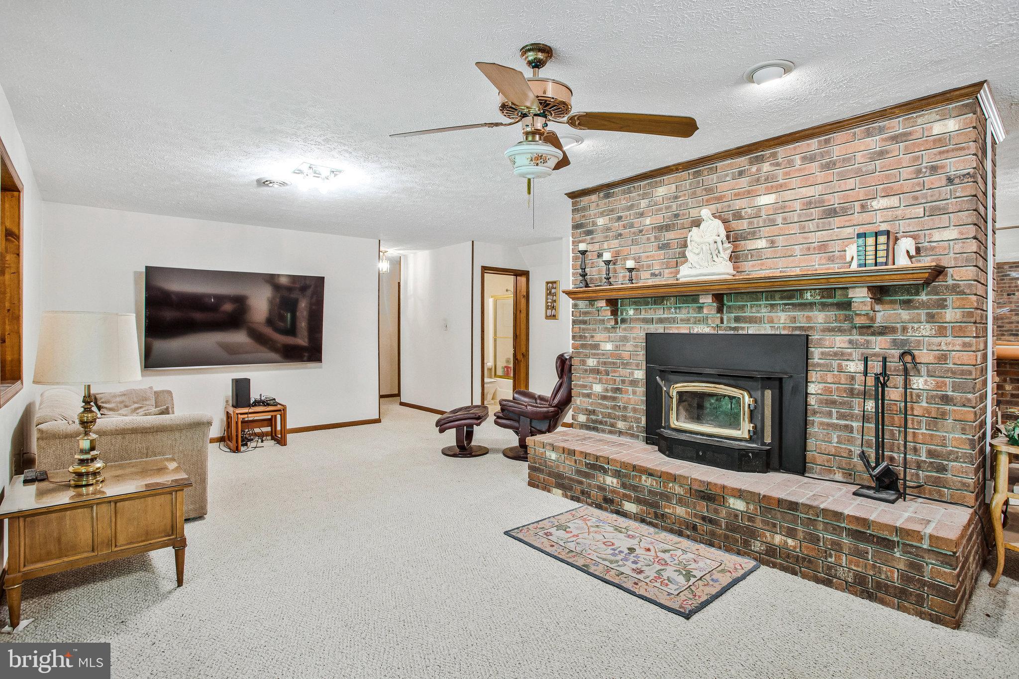 1021 Carson Drive Huntingtown, MD 20639 - Photo 23 of 33 a living room with furniture a flat screen tv and a fireplace