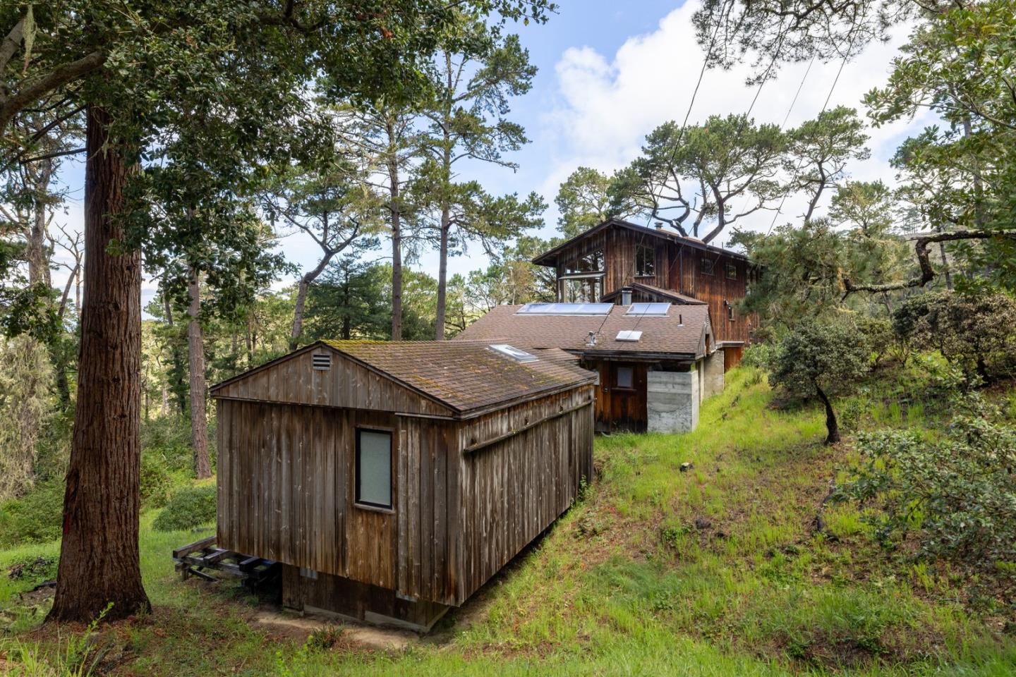73 Mt Devon Road Carmel Highlands, CA 93923 - Photo 5 of 88 a view of a wooden house with a small yard plants and large trees