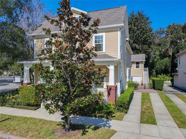 a front view of a house with a yard and potted plants