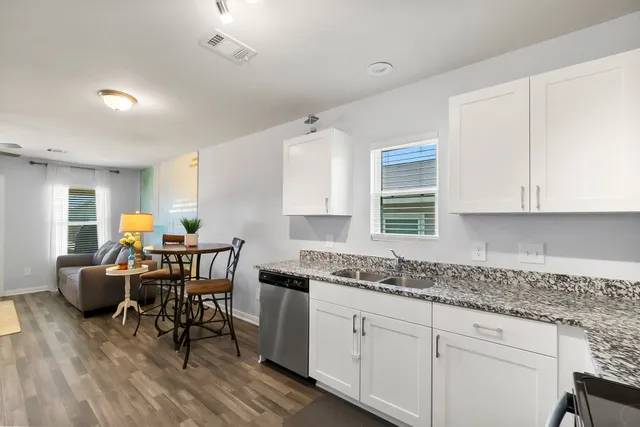 a kitchen with granite countertop a refrigerator stove and sink