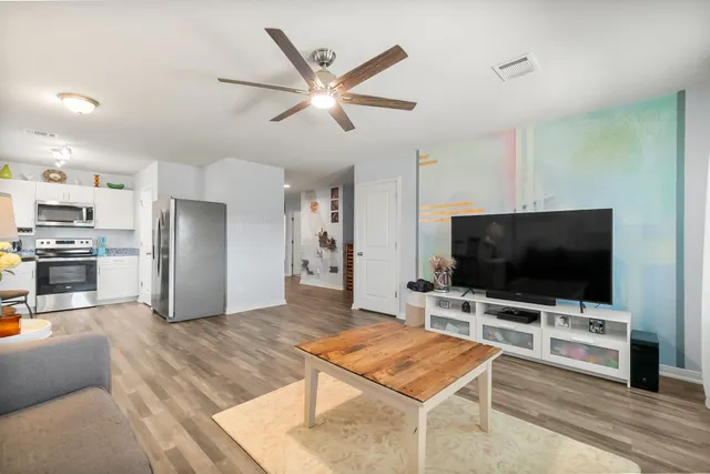 a living room with furniture and kitchen view