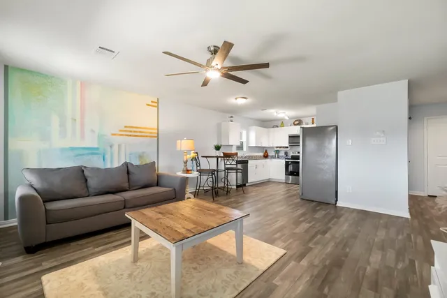 a living room with furniture and a wooden floor