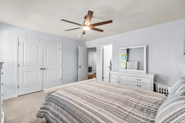 a bedroom with a bed and a ceiling fan