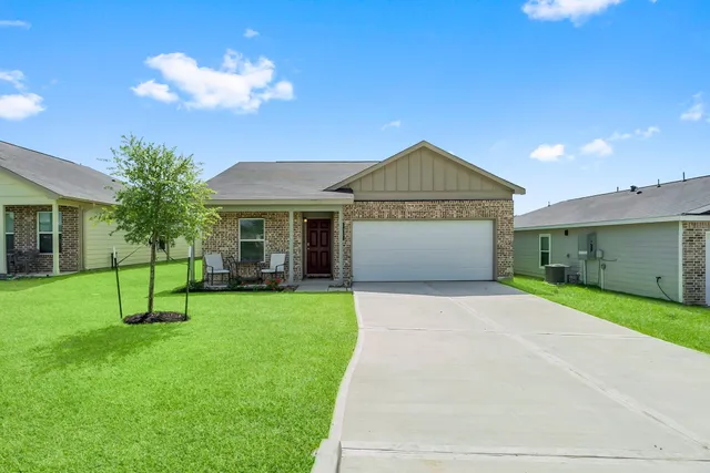 a front view of a house with a garden and yard