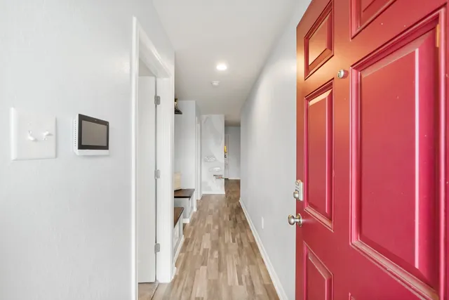 a view of a hallway with wooden floor and staircase