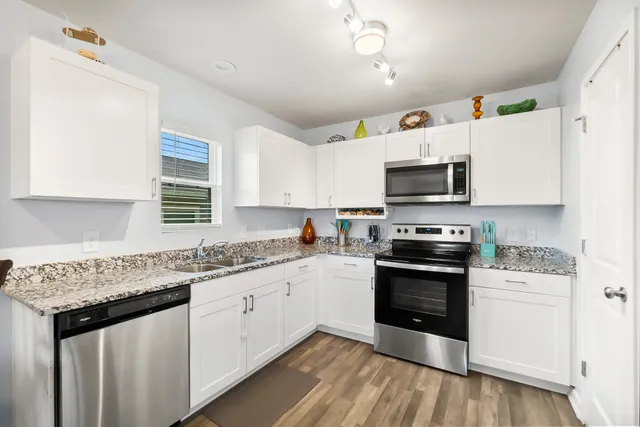 a kitchen with granite countertop white cabinets and white appliances